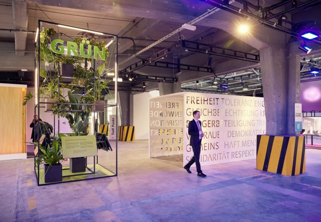 Die Ausstellungshalle der Stadt Mannheim mit Bepflanzung und blauem Licht