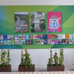 Plakate und Postkarten vergangener und Zukünftiger Garten- und Landesschauen hängen an einer Wand. Davor Blumenkästen